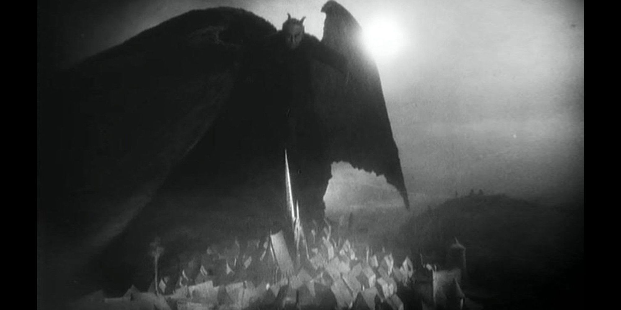 Mephistopheles standing atop a hill spreading his wings at night in Faust (1926)
