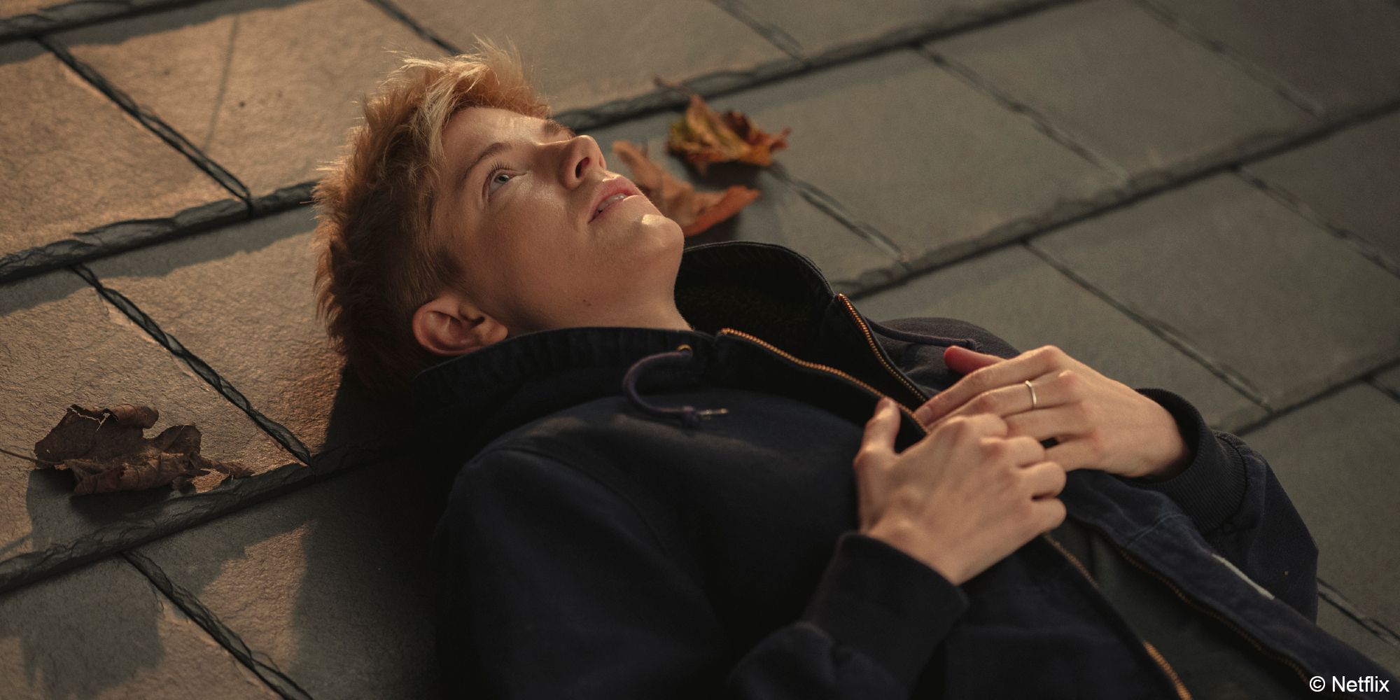 Feel Good_Mae lays on a rooftop looking up at the sky