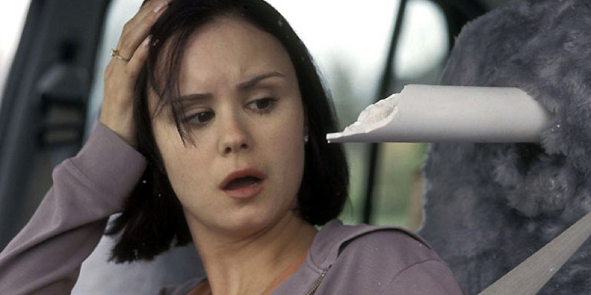 A woman staring at a broken pole that has pierced through her car seat