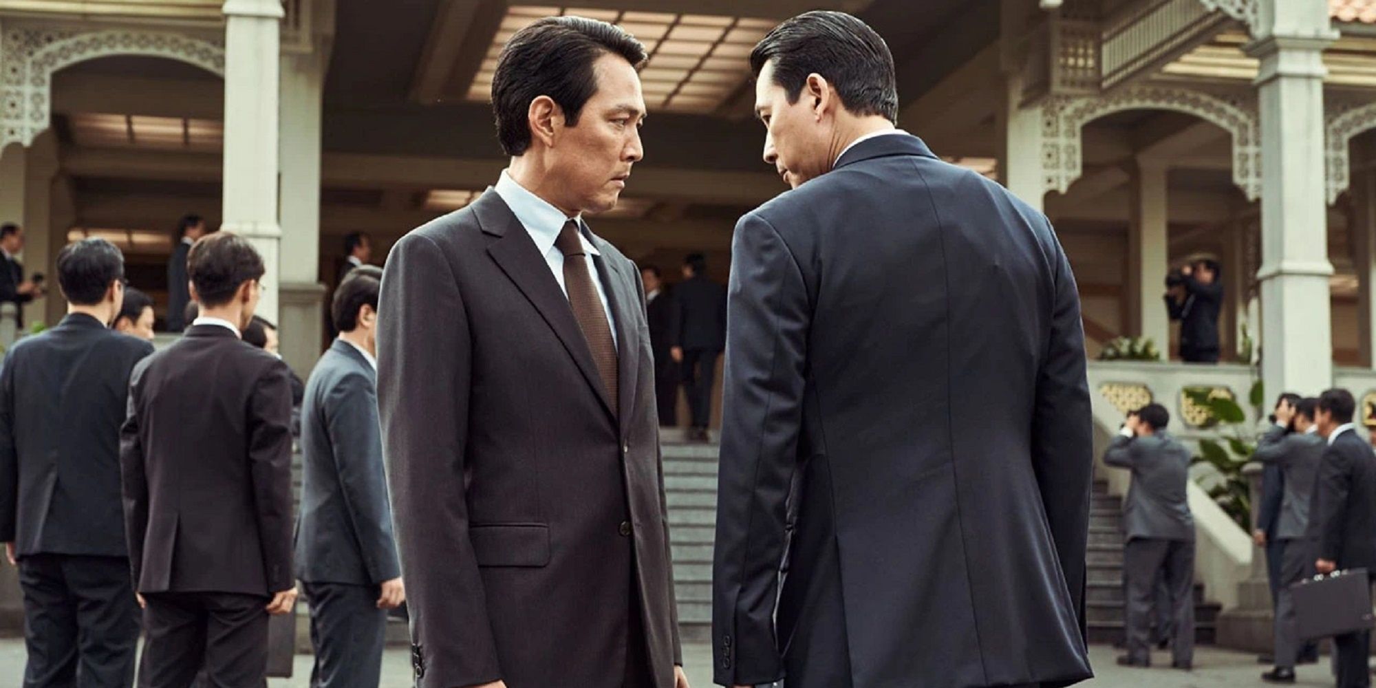 Two men in suits looking at each other 