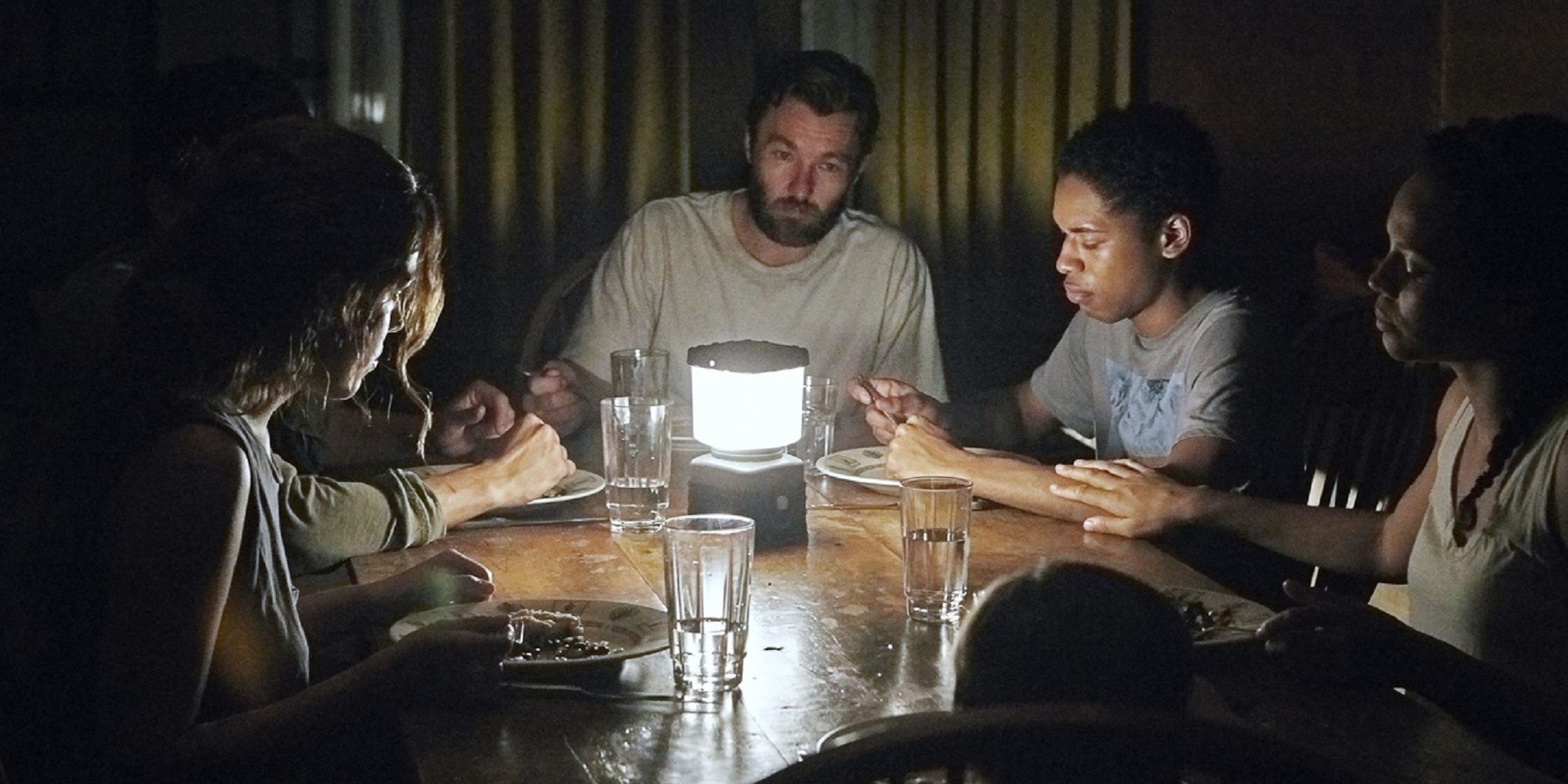 Joel Edgerton, his family, and the strangers at the dinner table in 'It Comes At Night'