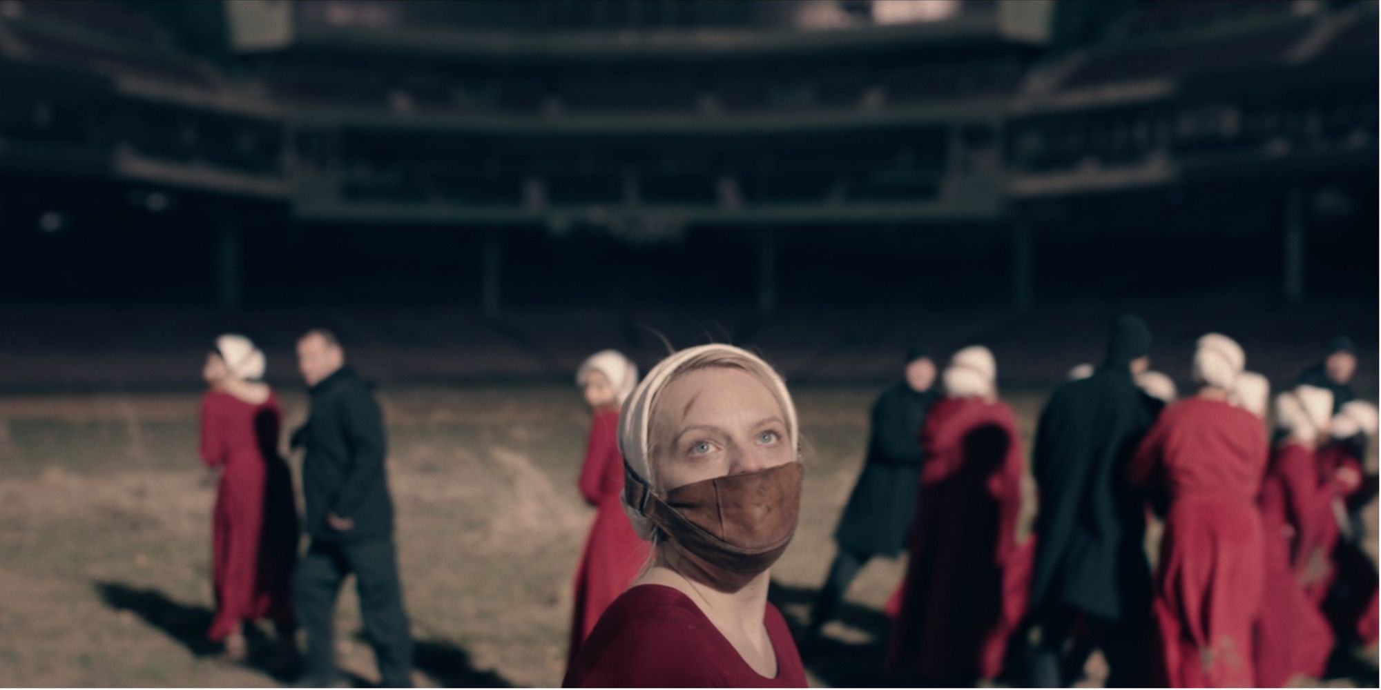 June with a mask, in a empty stadium with guards