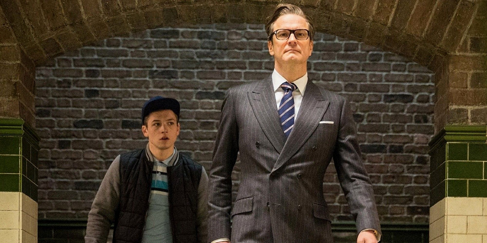 Two men walking, one in a suit and the other in casual wear, in Kingsman: The Secret Service