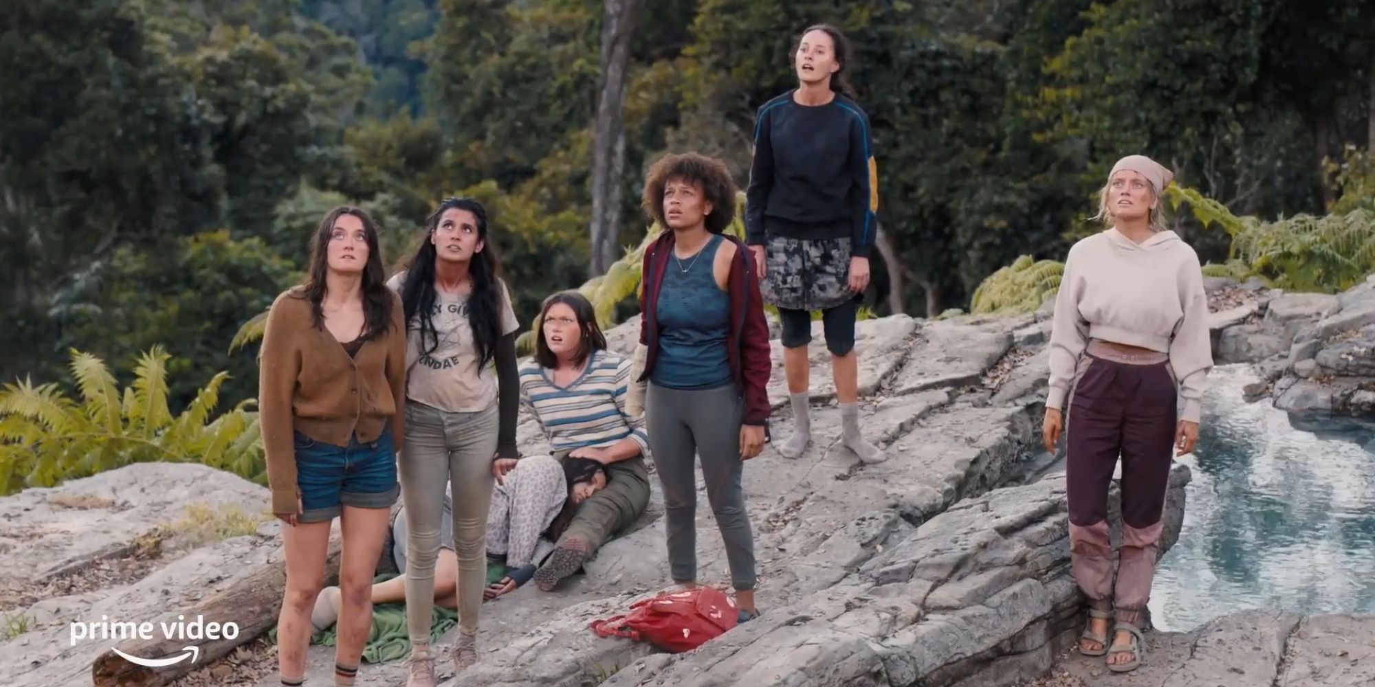 A group of teenage girls standing on a rock in The Wilds
