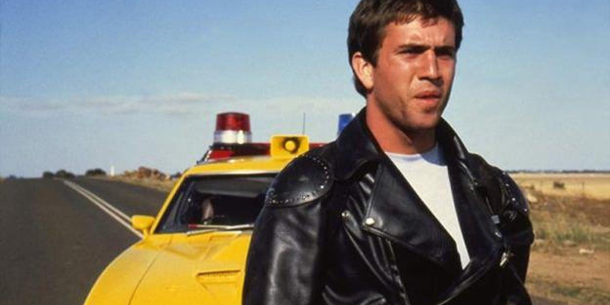 Mel Gibson standing in front of car in Mad Max