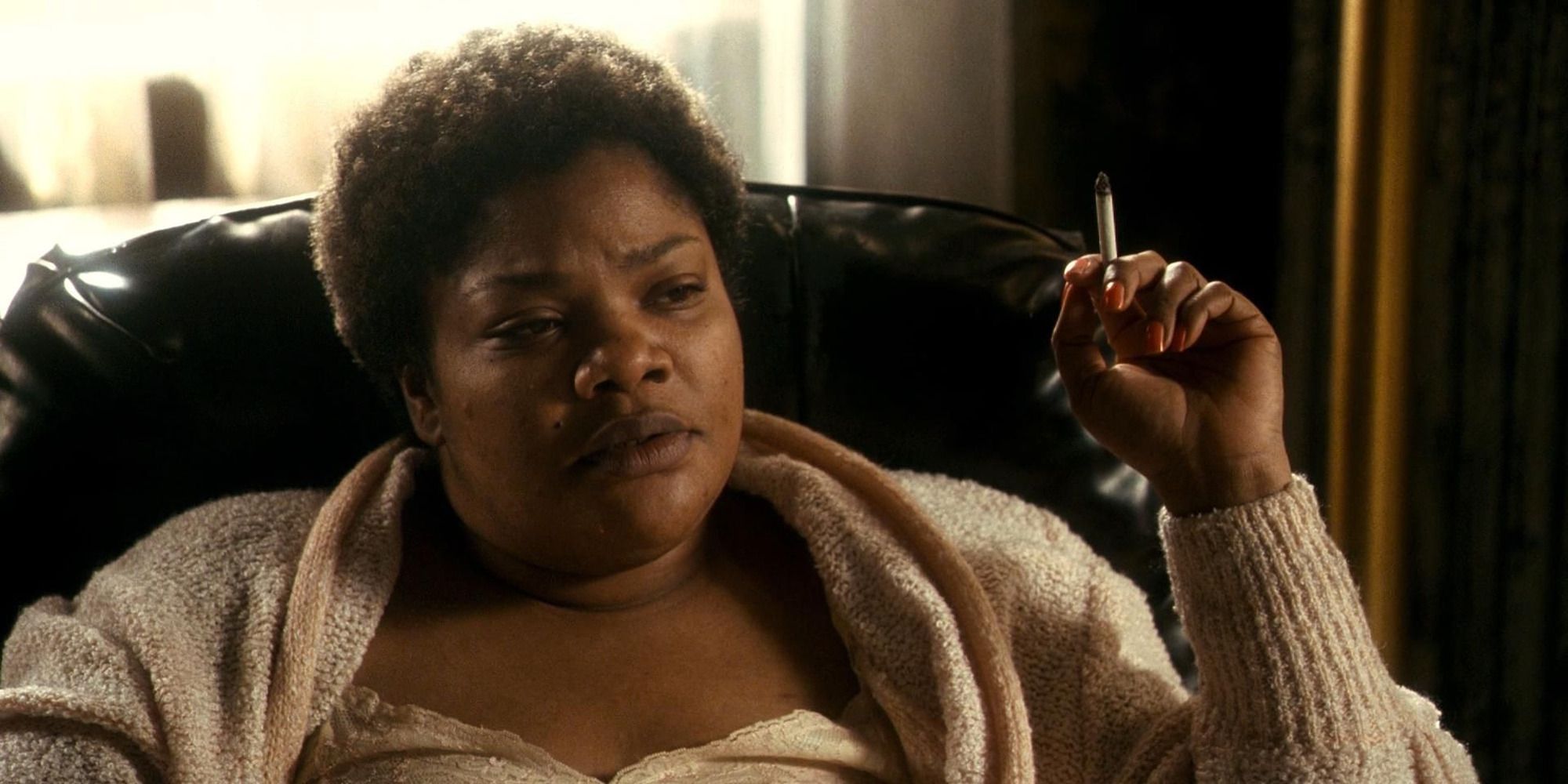 Mo'Nique as Mary smoking a cigarette while sitting on a couch in Precious.