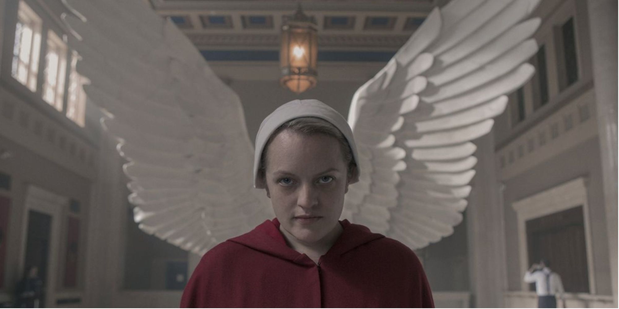 Offred looking at the camera with wings behind her head