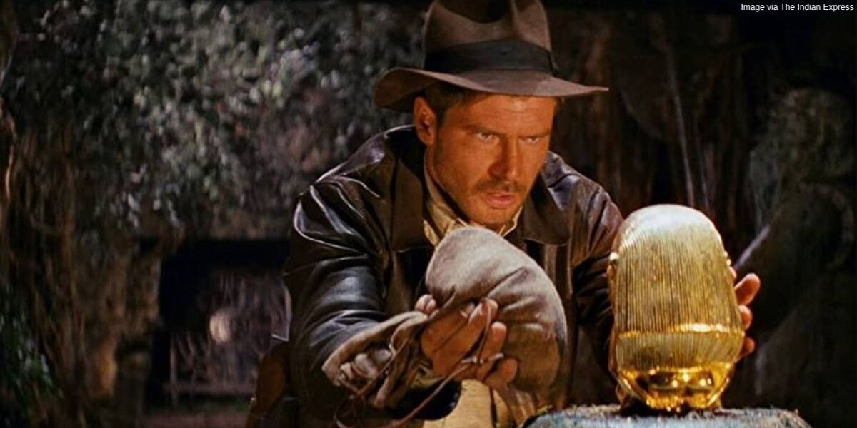 Indiana Jones s'apprête à saisir l'idole d'or dans Les Aventuriers de l'Arche perdue.