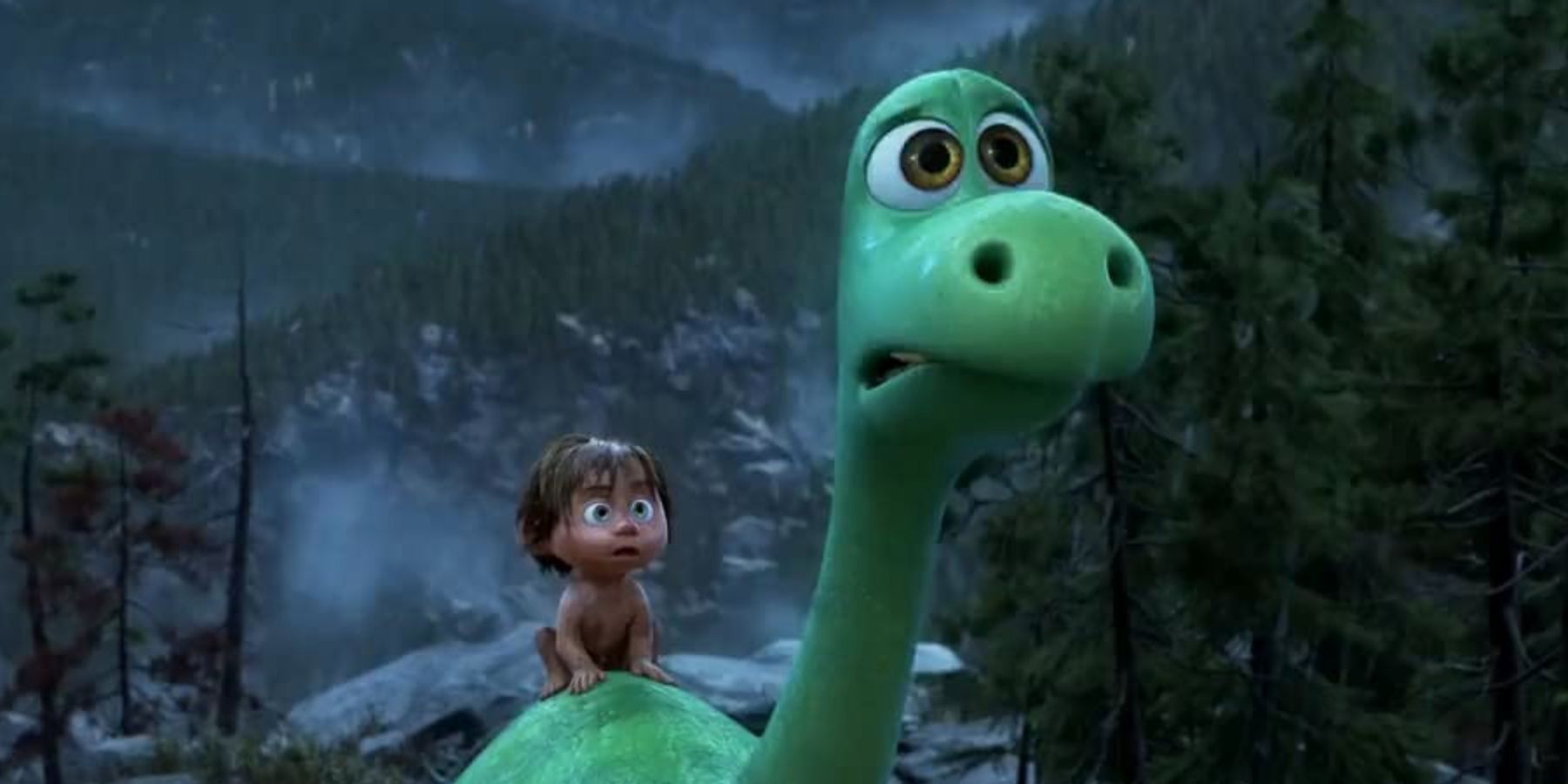 A young boys sits on the back of a green dinosaur as they both look anxiously at what lies ahead of them. 