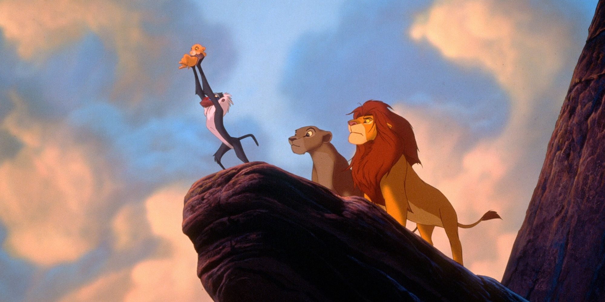 Rafiki holding up Simba at Pride Rock in The Lion King.