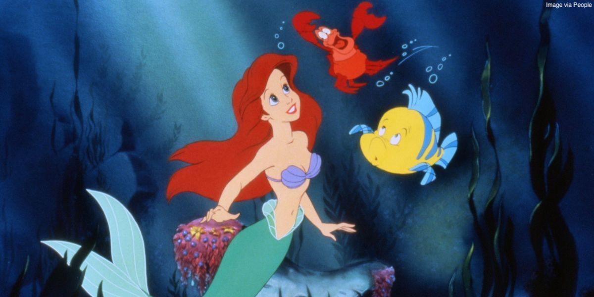 Ariel smiles at Sebastian and Flounder underwater in the Disney animation The Little Mermaid