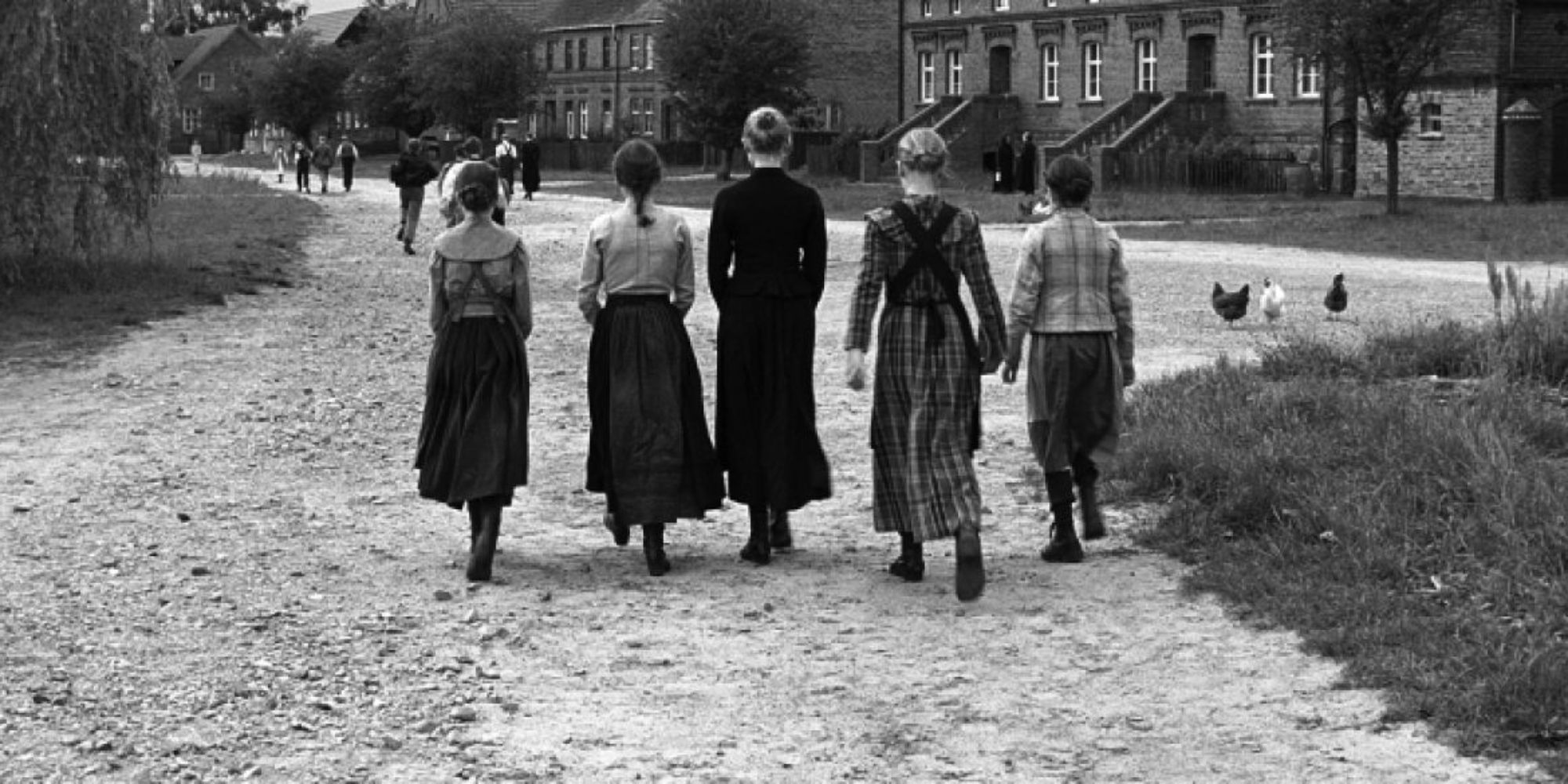 A group of people walk in a rural German village in ‘The White Ribbon’