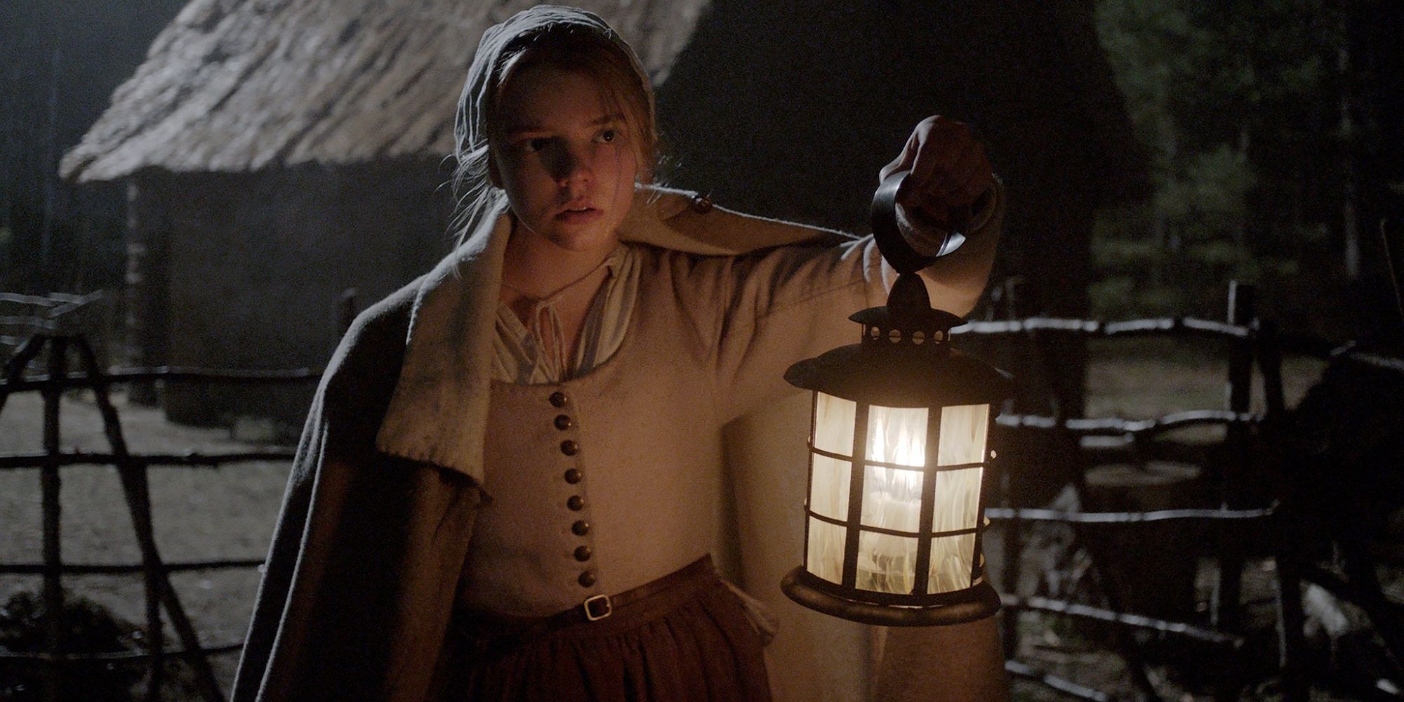 Thomasin at nighttime in The Witch looking for something in the dark with a lantern.