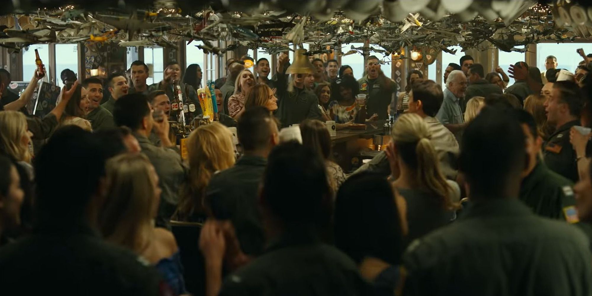 A crowd gathered around the bar in Top Gun: Maverick