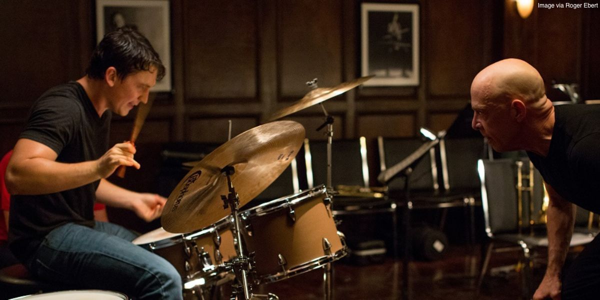 Miles Teller as Andrew Neiman playing the drums while J.K. Simmons as Terence Fletcher looks on in 'Whiplash'
