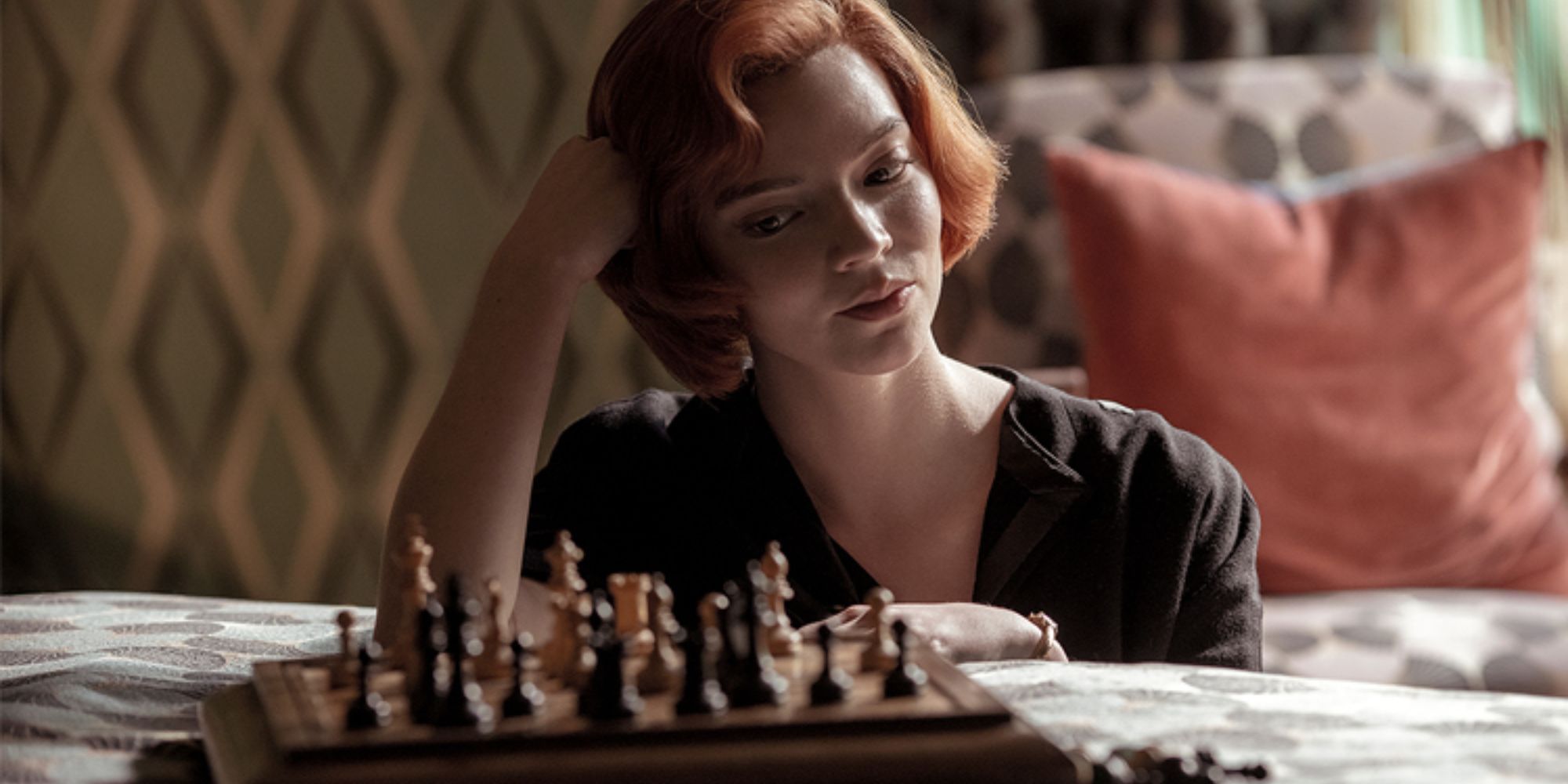 Anya Taylor-Joy sitting by the bed with a board of chess on it in The Queen&rsquo;s Gambit