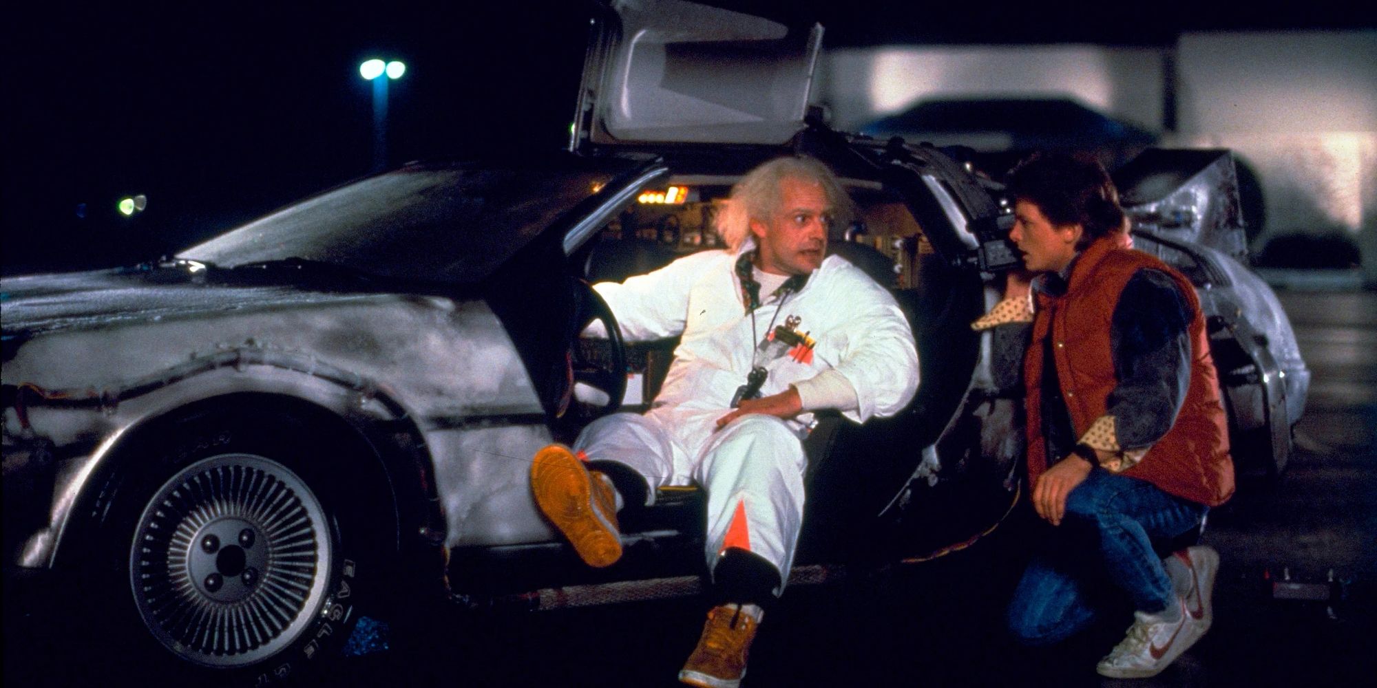 Doc and Marty talking beside the Delorean time machine in 'Back to the Future'