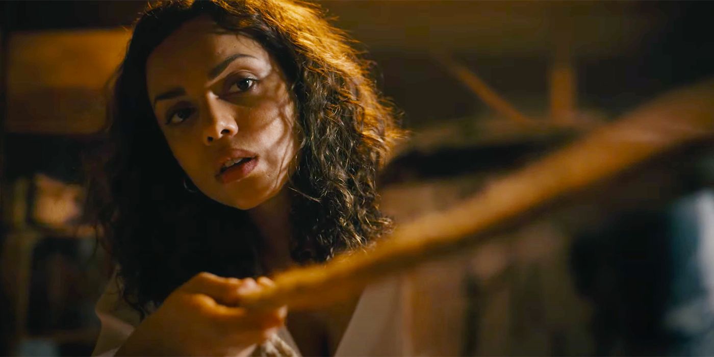 Georgina Campbell de The Barbarian sostiene un palo y mira algo fuera de cámara.