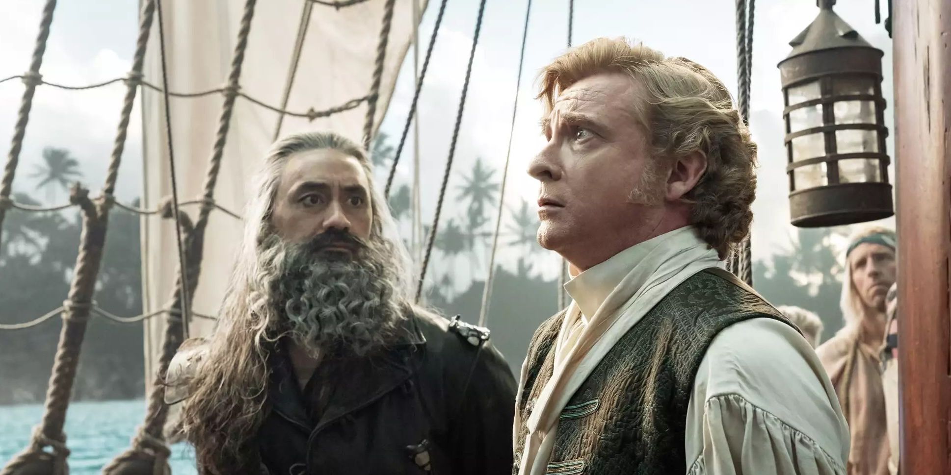 Taika Waititi looks adoringly at Rhys Darby on a ship in a scene from Our Flag Means Death