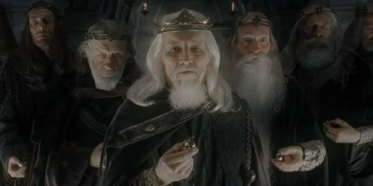 Nine Kings of Men from 'The Lord of the Rings: Fellowship of the Ring' standing side-by-side and holding golden rings. The lighting is dark, and they wear grey robes.