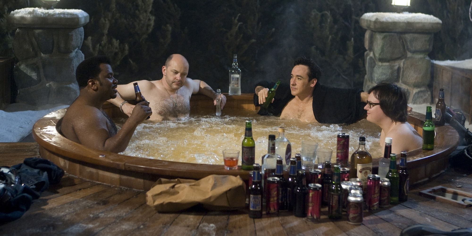 The main characters in the hot tub time machine next to lots of empty beer bottles 