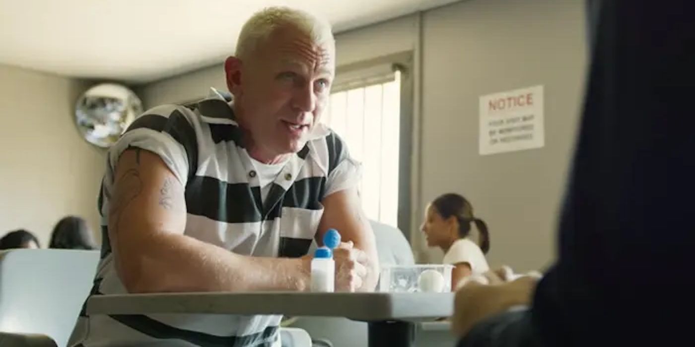 Daniel Craig talking at a table in prison in Logan Lucky