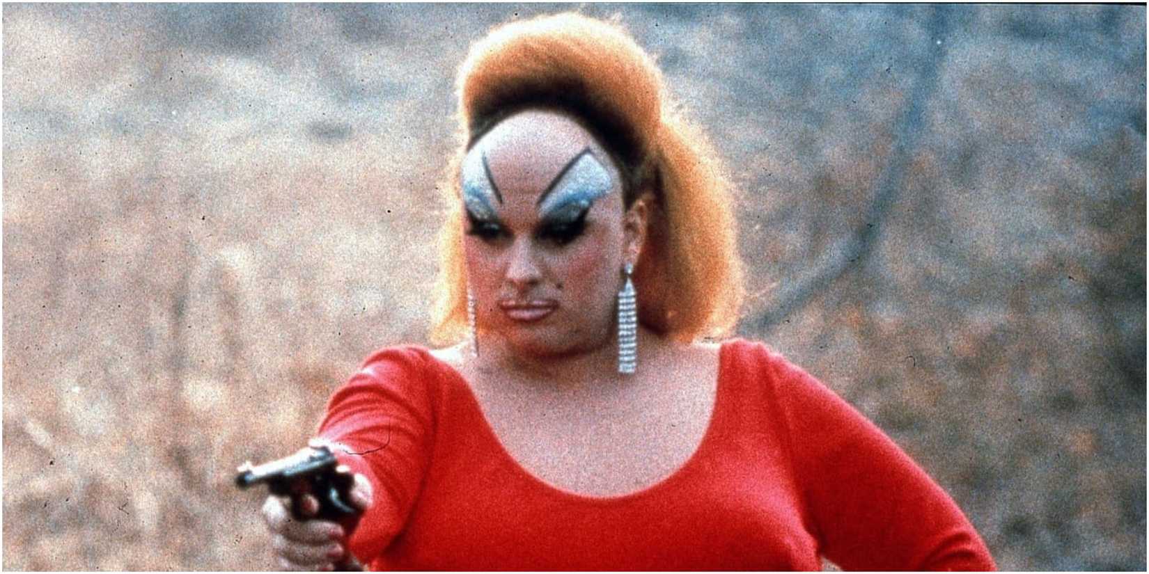 Divine aiming a gun in Pink Flamingos