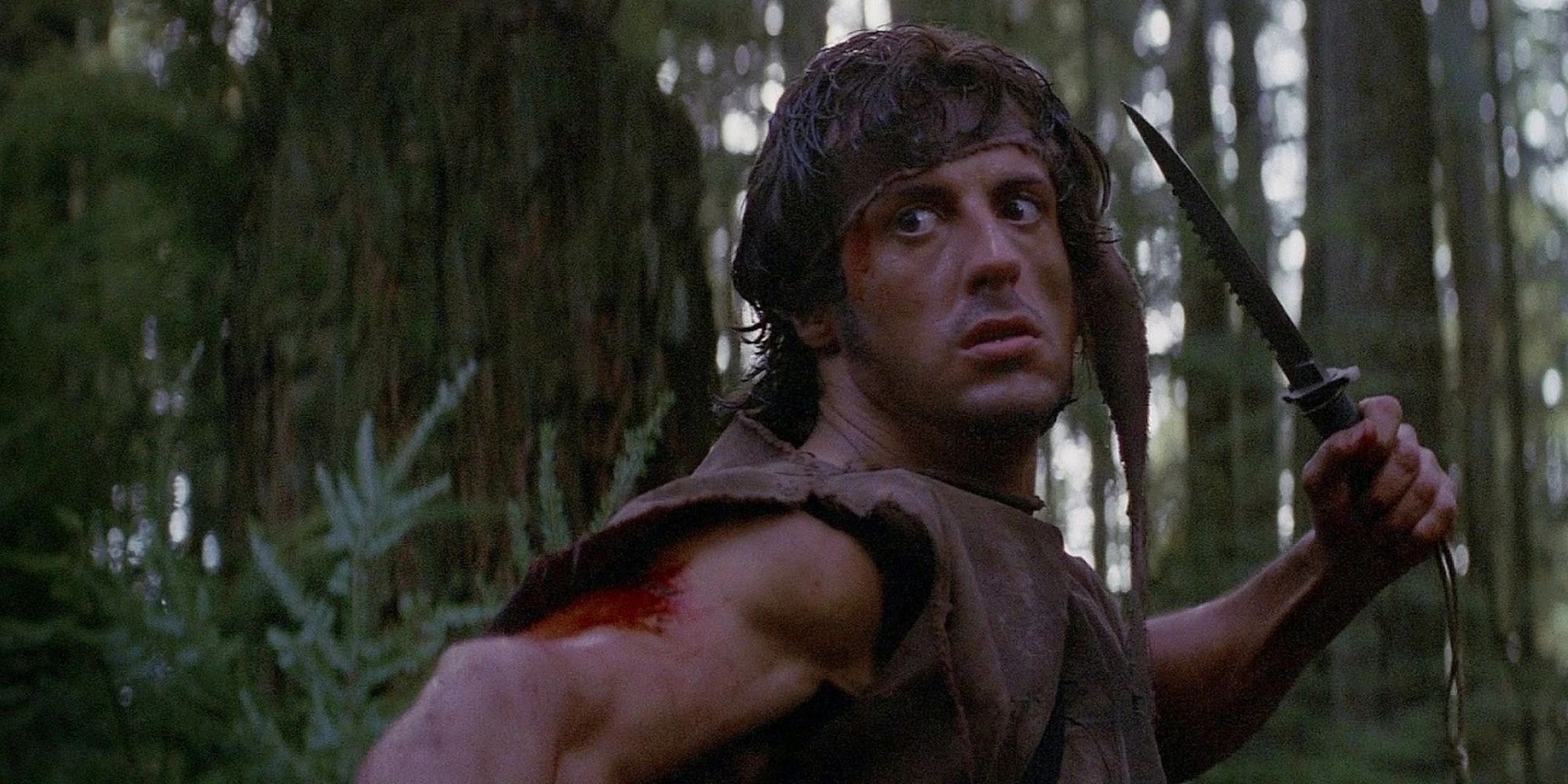 John Rambo (Sylvester Stallone) holds a knife in 'First Blood' (1982) 