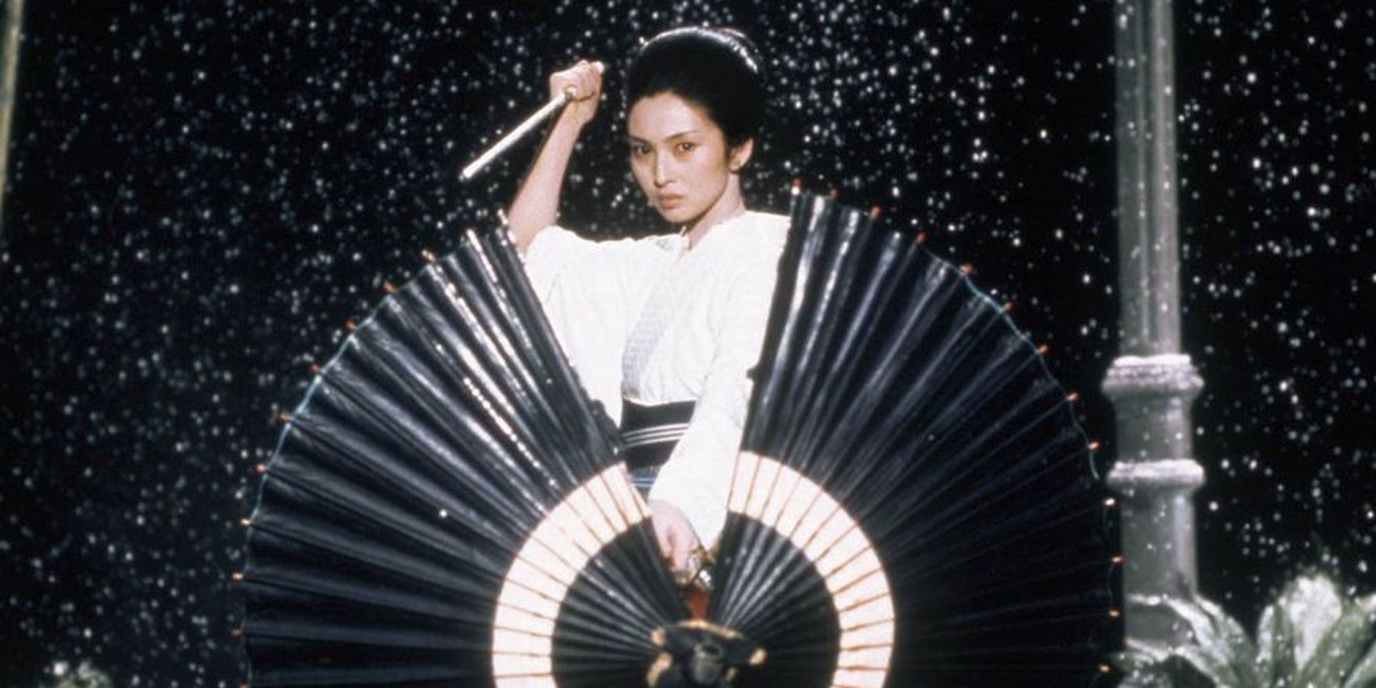 Lady Snowblood wielding a knife and staring at the camera in Lady Snowblood.