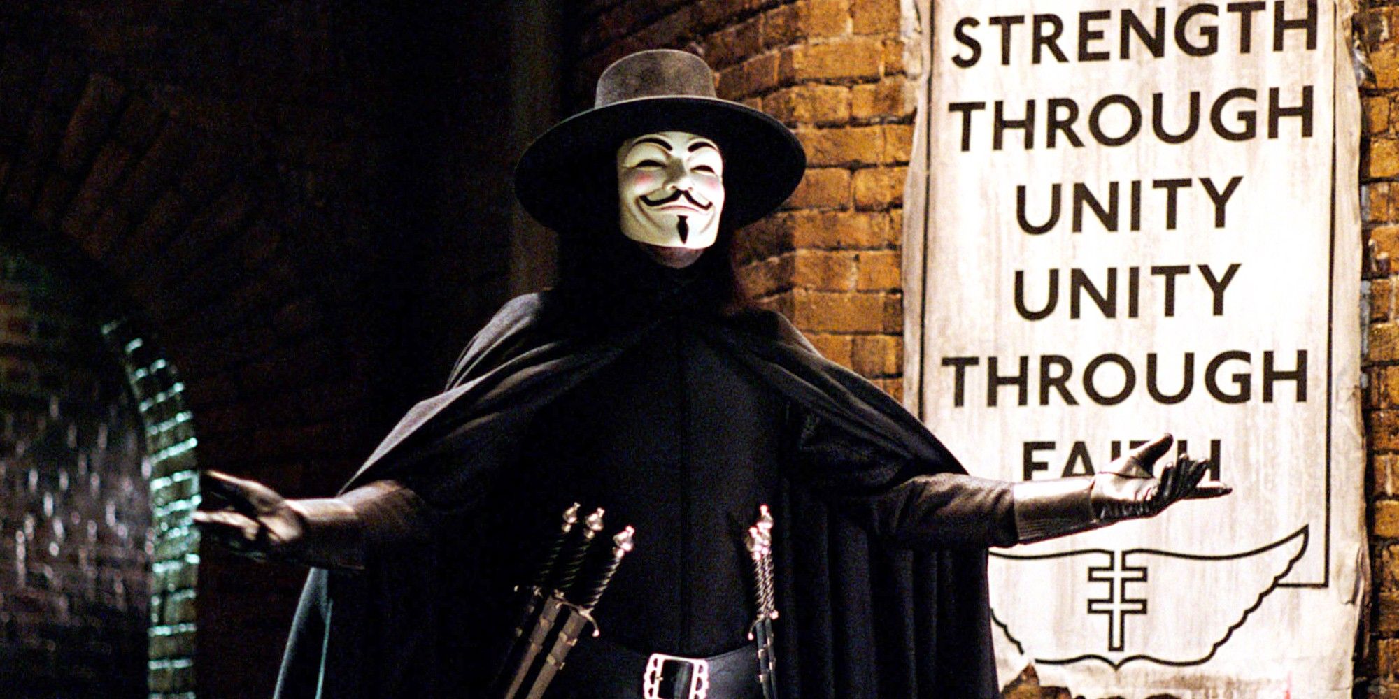 A masked vigilante known as V introduces himself in a seedy alleyway which sports a propaganda poster on the wall. 