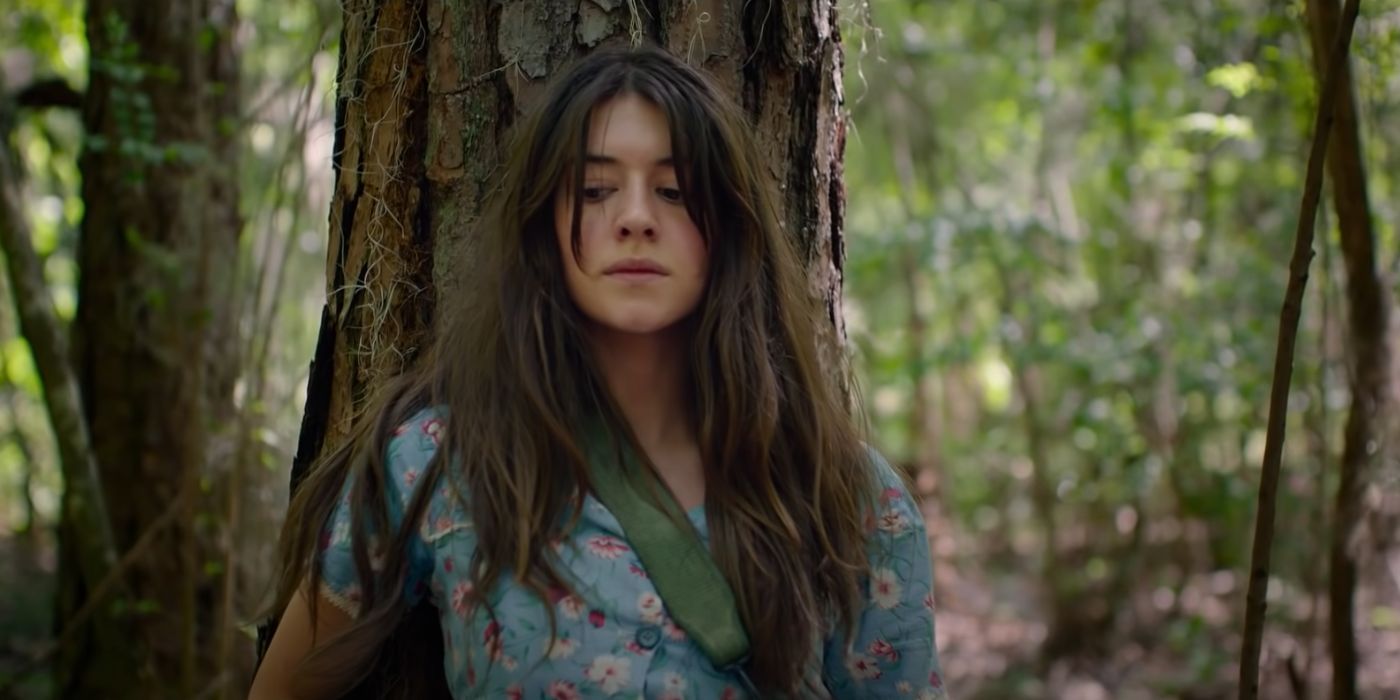 A woman hiding behind a tree