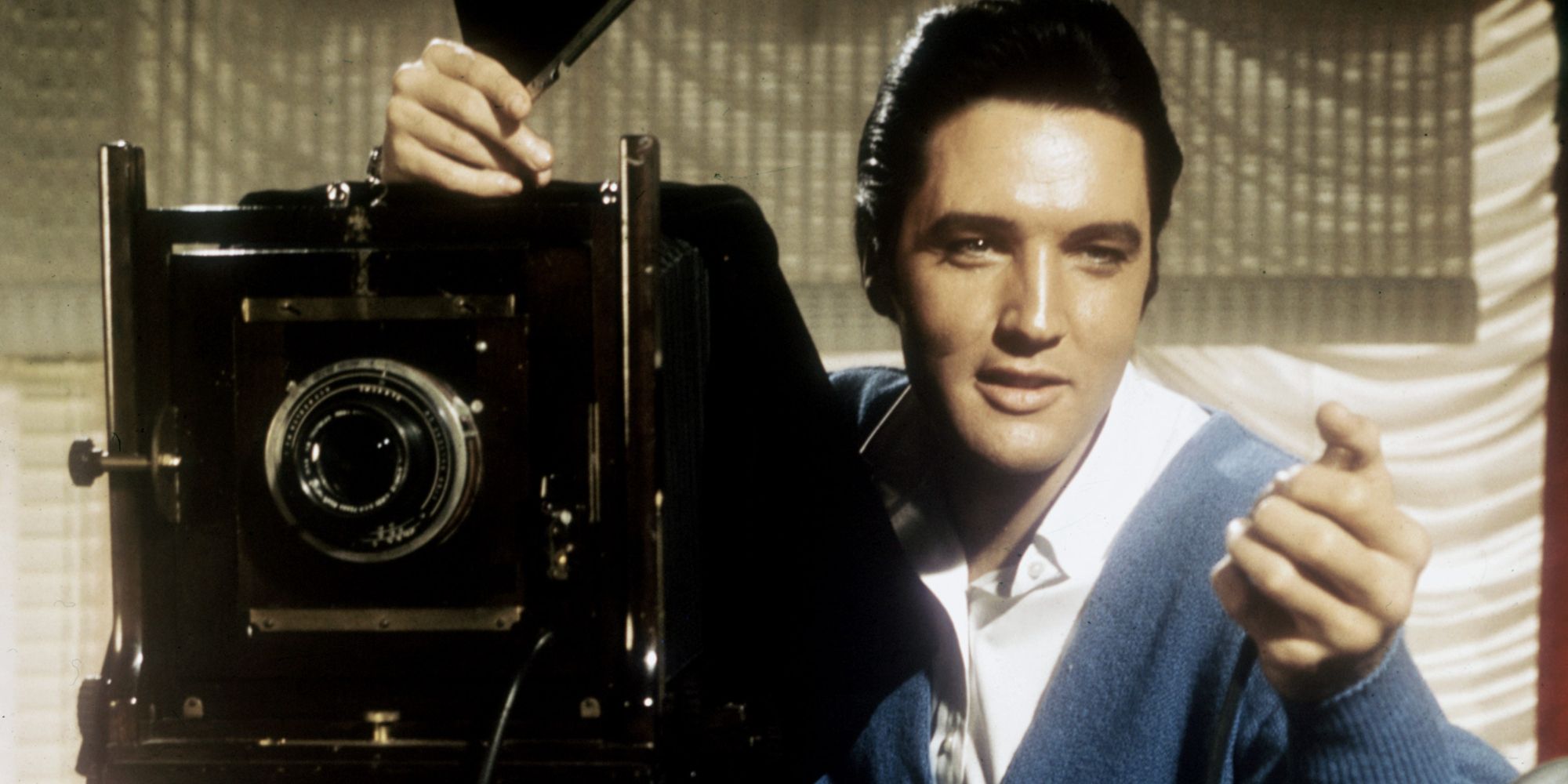 Elvis Presley sitting behind a camera 