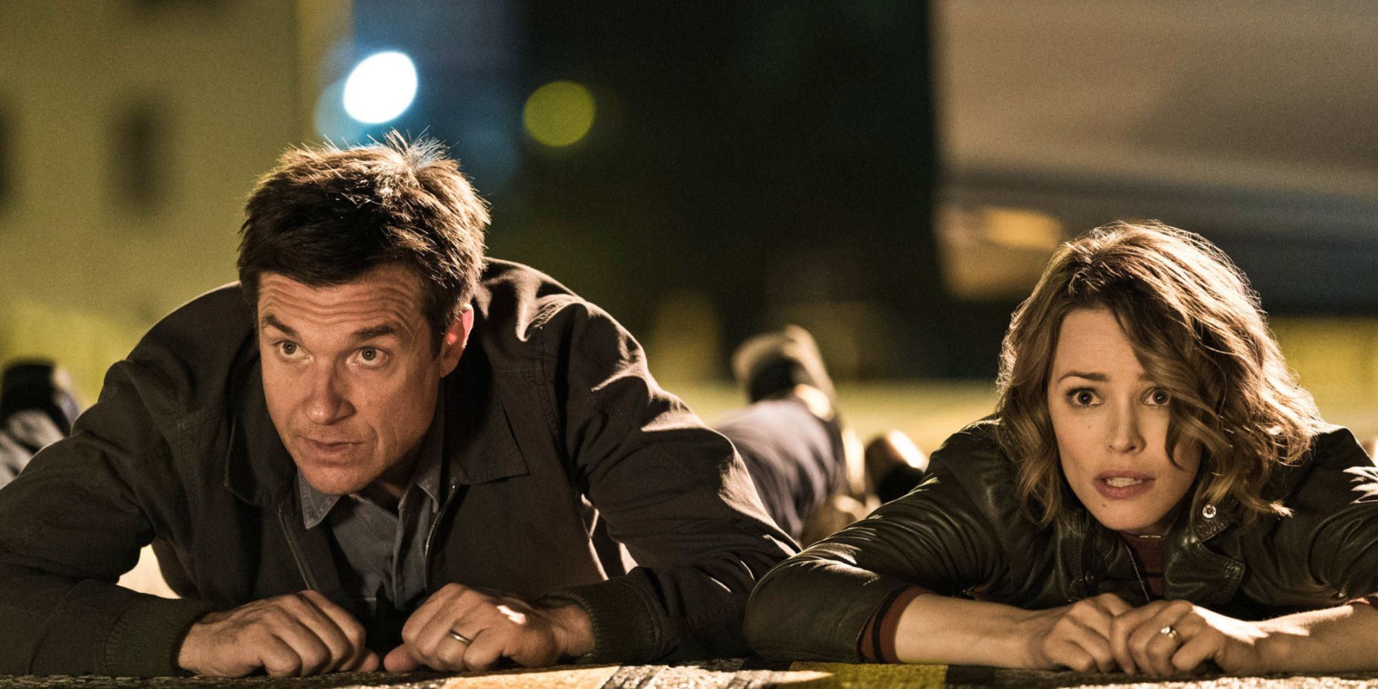 Jason Bateman and Rachel McAdams lying on the ground looking horrified 