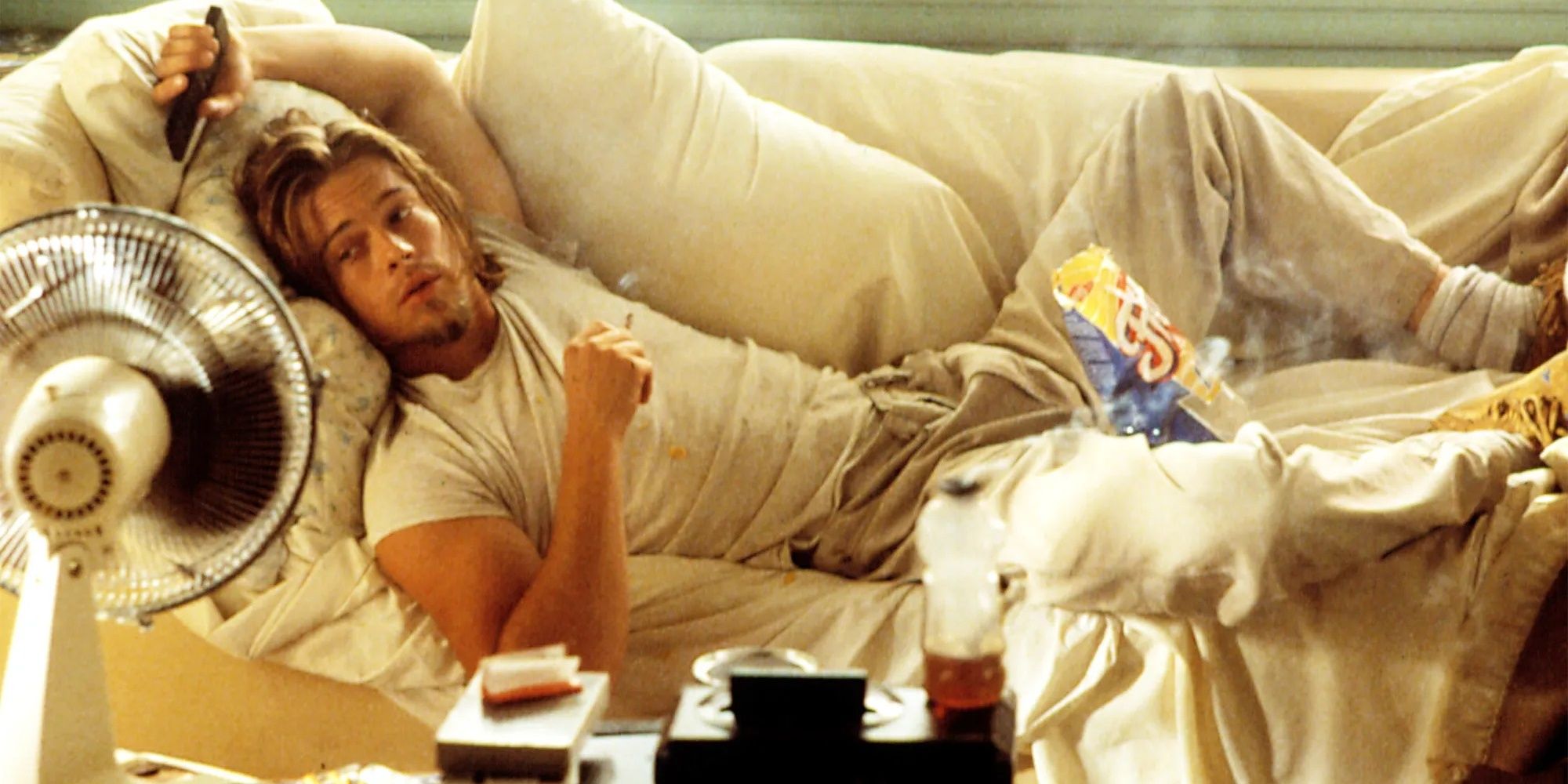 Floyd laying on the couch in sweatpants with a bag of Fritos in True Romance.