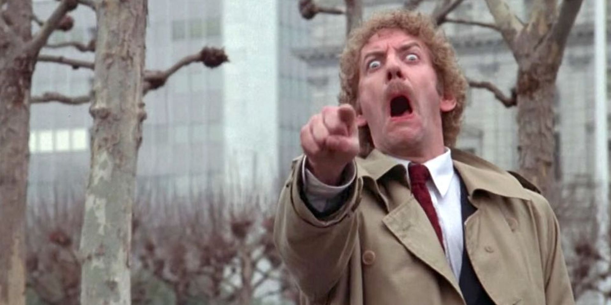 A man pointing at the screen and looking terrified in Invasion of the Body Snatchers