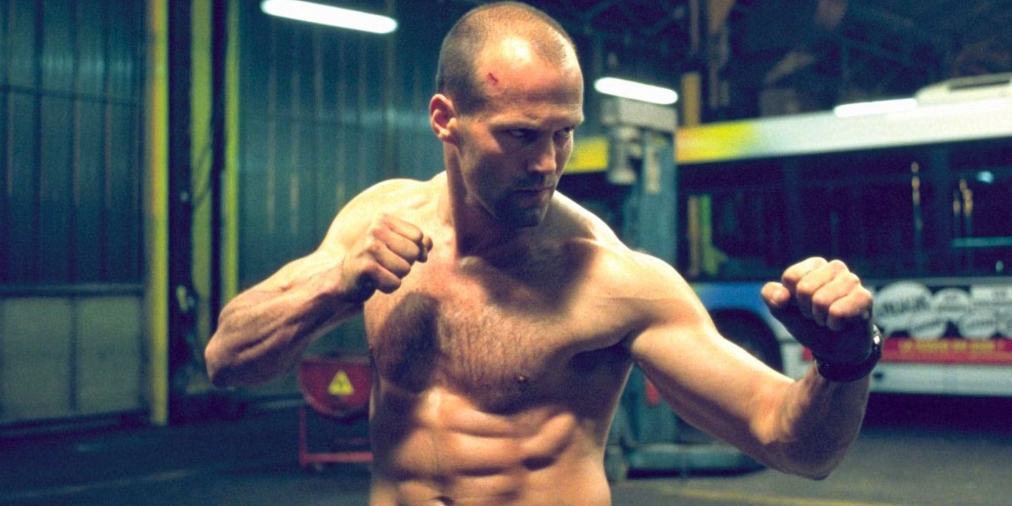 Jason Statham with his shirt off and his fists up ready to fight in The Transporter