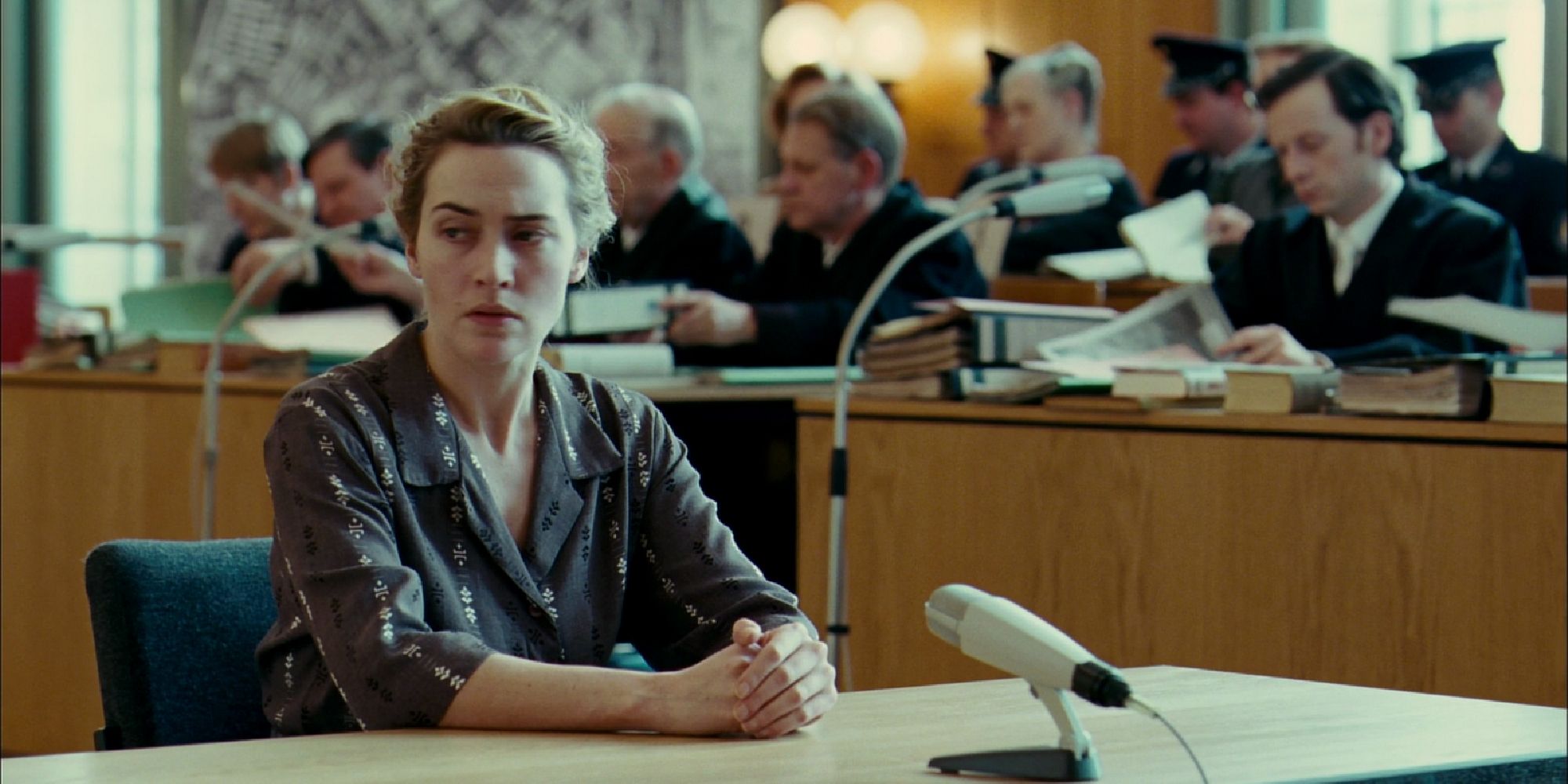 Kate Winslett sitting in a courtroom in The Reader (2008)