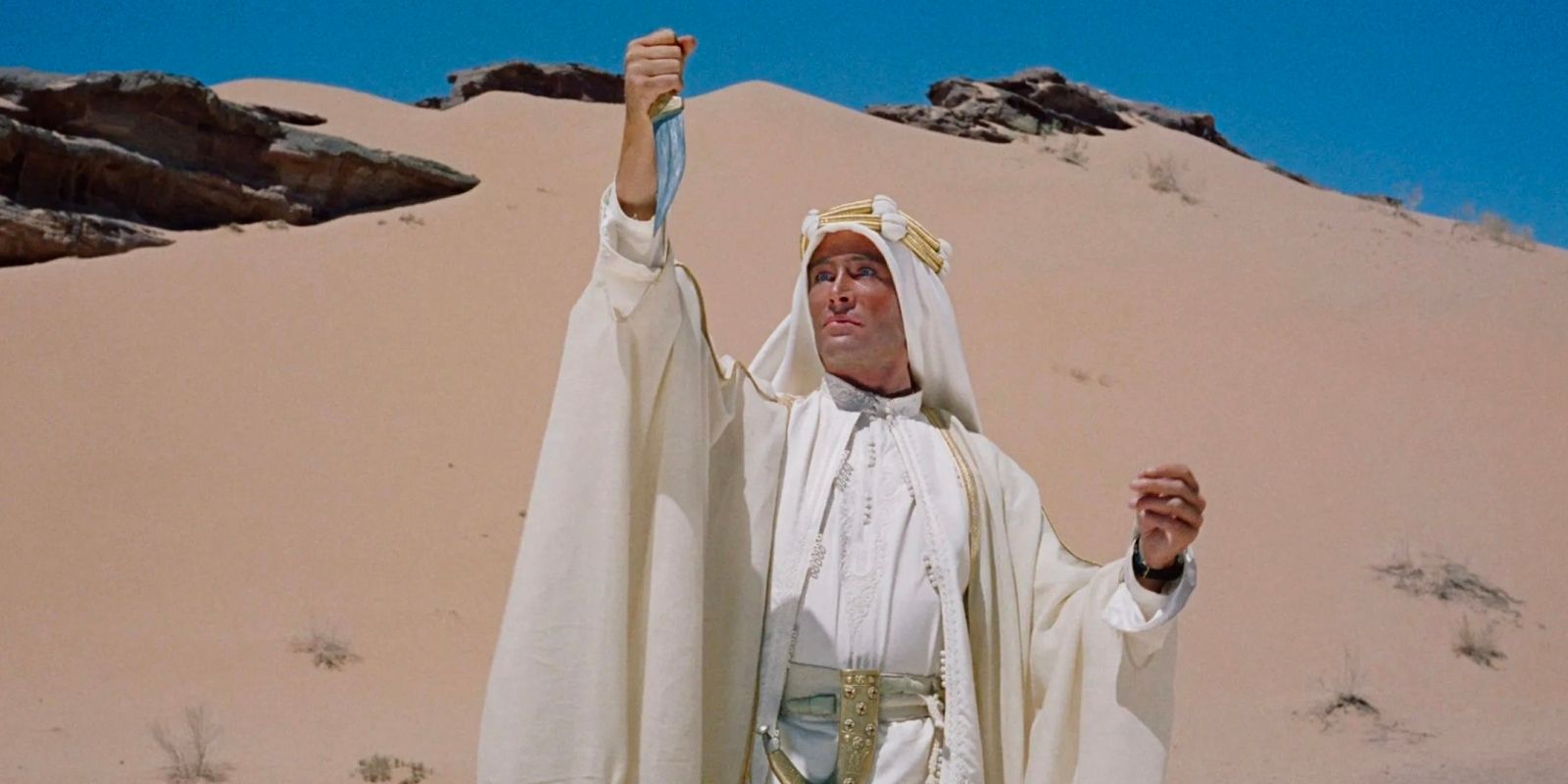 T.E. Lawrence raising his hand in the desert in Lawrence of Arabia