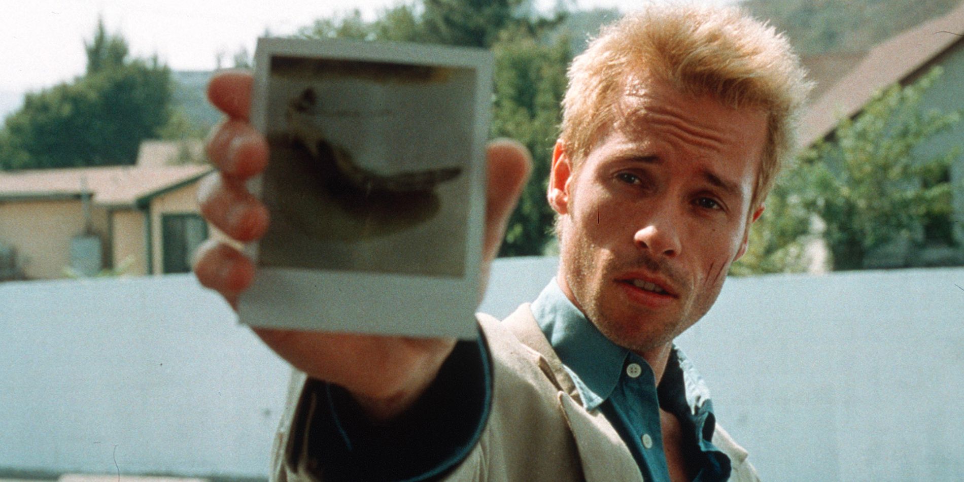 Leonard Shelby (Guy Pearce) questions someone about a photograph of a car in 'Memento'.