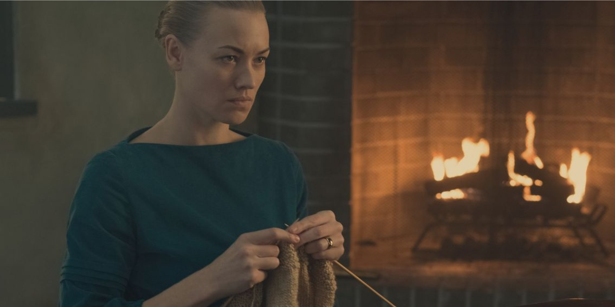 Serena Joy knitting by the fire