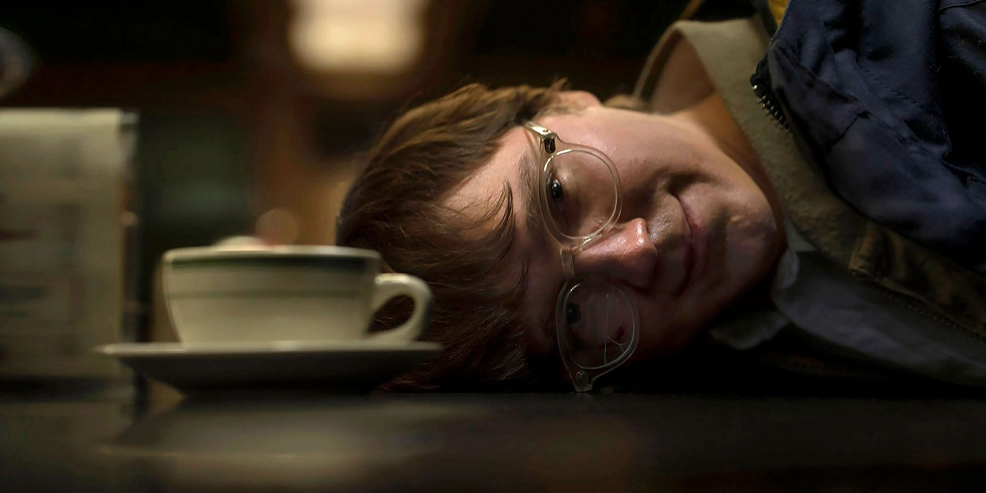 The Riddler with his head down on the coffee shop counter in The Batman.