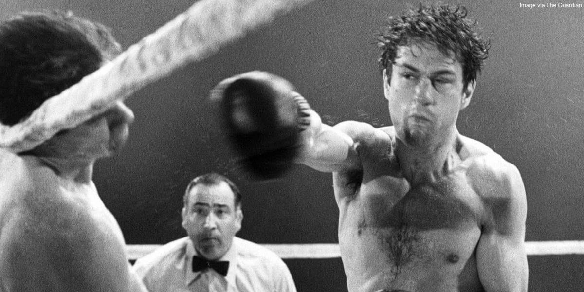 Robert De Niro punching a guy in a boxing ring in Raging Bull