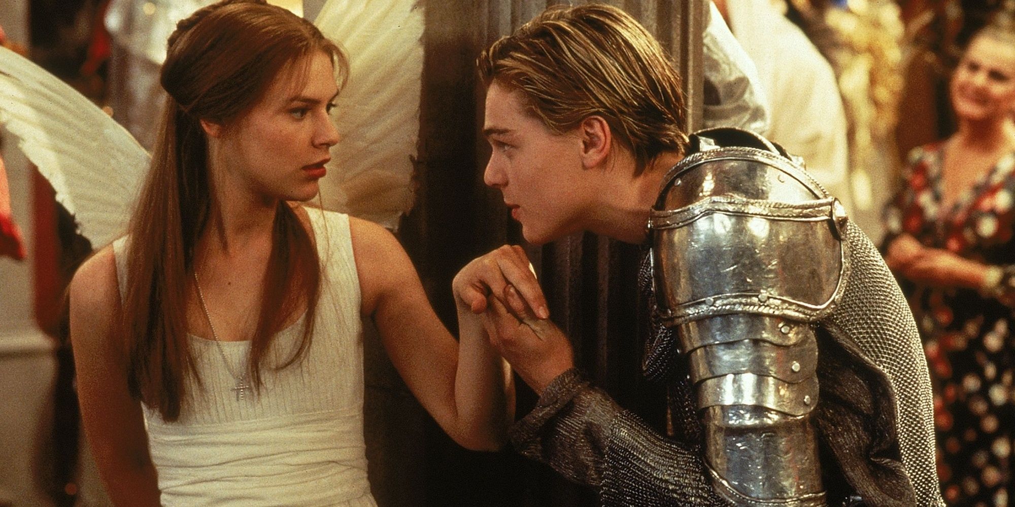 Romeo in a knight costume kissing the hand of Juliet, who is in an angel costume.