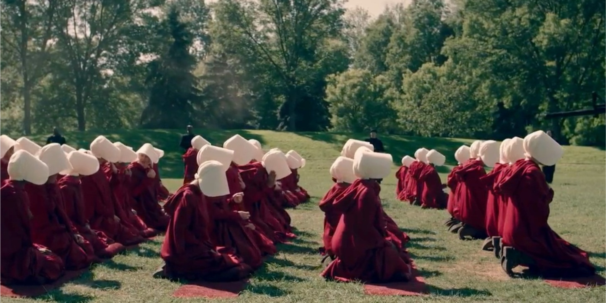 Rows of handmaids dressed in red kneeling down