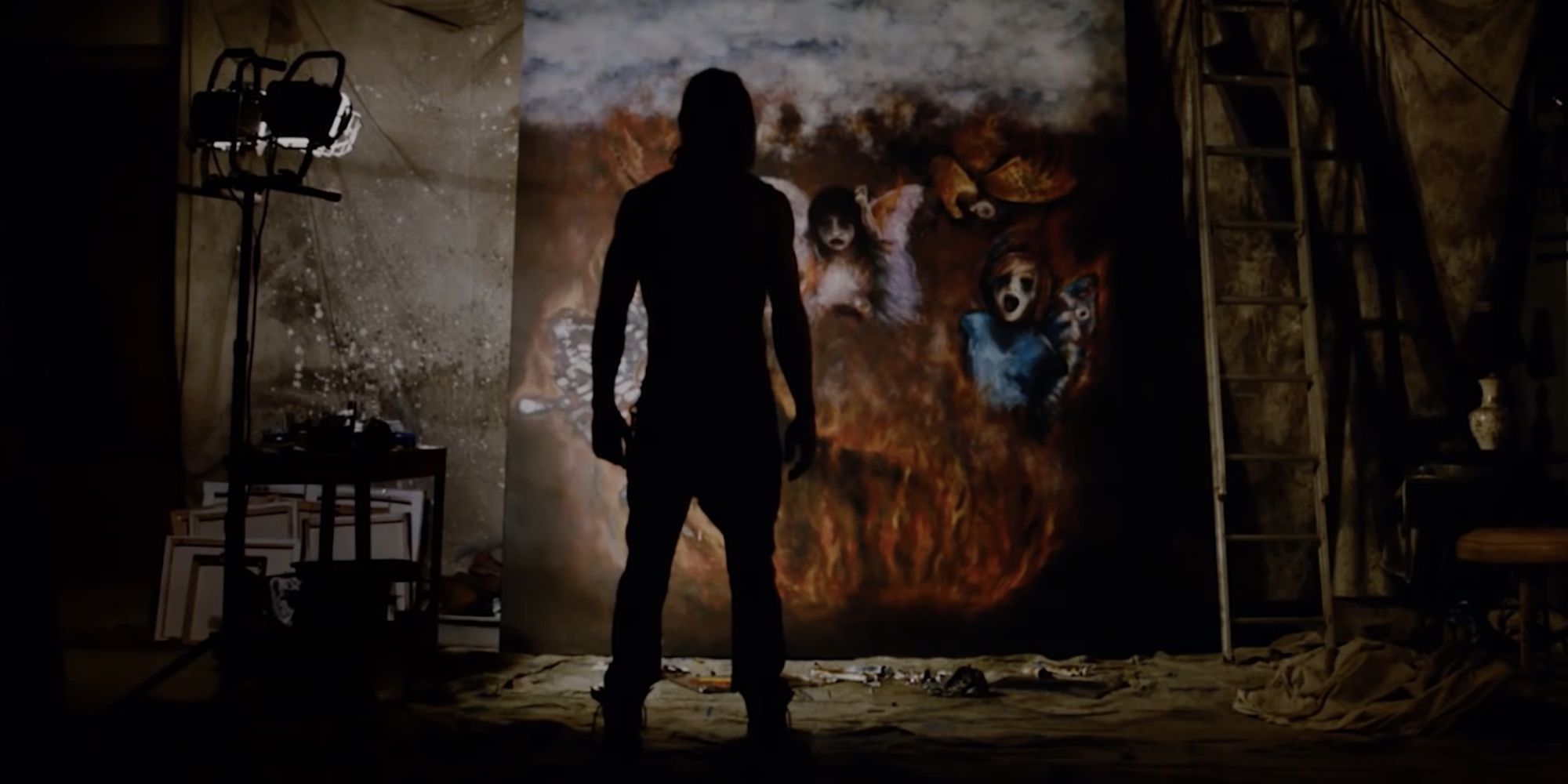 A man stands in front of a disturbing painting in The Devil's Candy