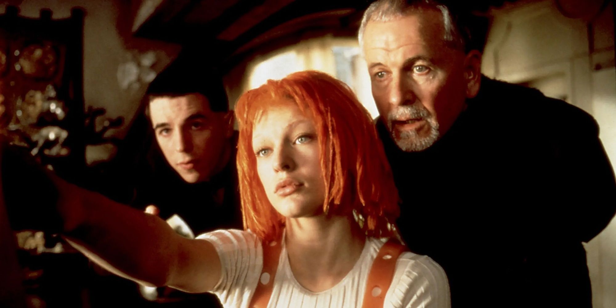 Milla Jovovich as Leeloo Dallas and Ian Holm as Vito Cornelius, a priest looking at a computer, in The Fifth Element.