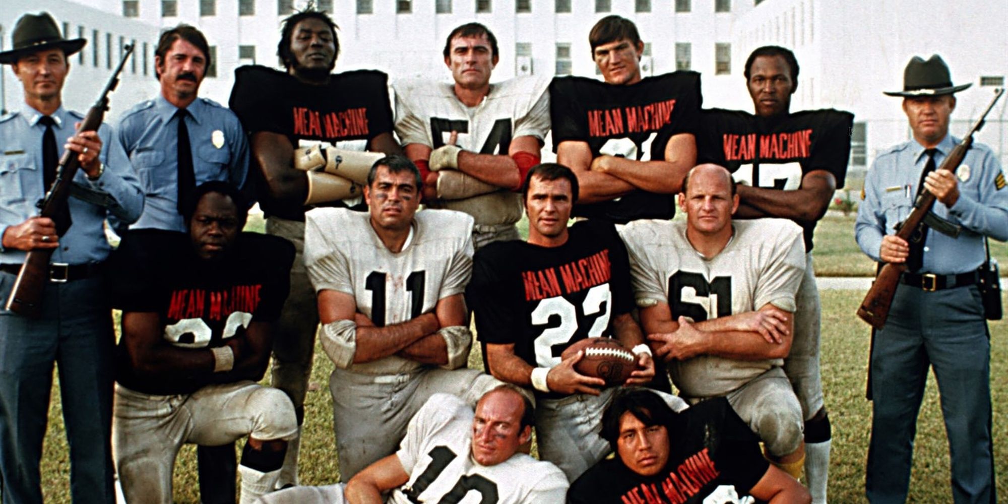 A group of football players pose in-between prison guards