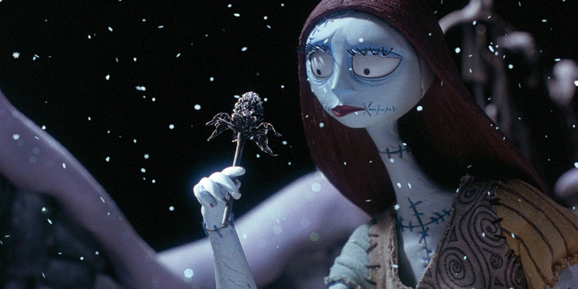 Sally holding a spider lollipop in the snow.