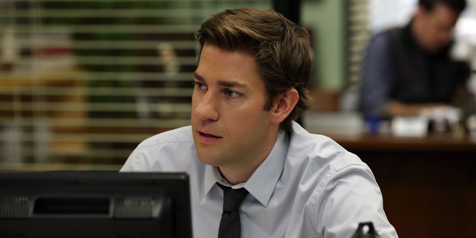 Jim Halpert from The Office sitting at his desk