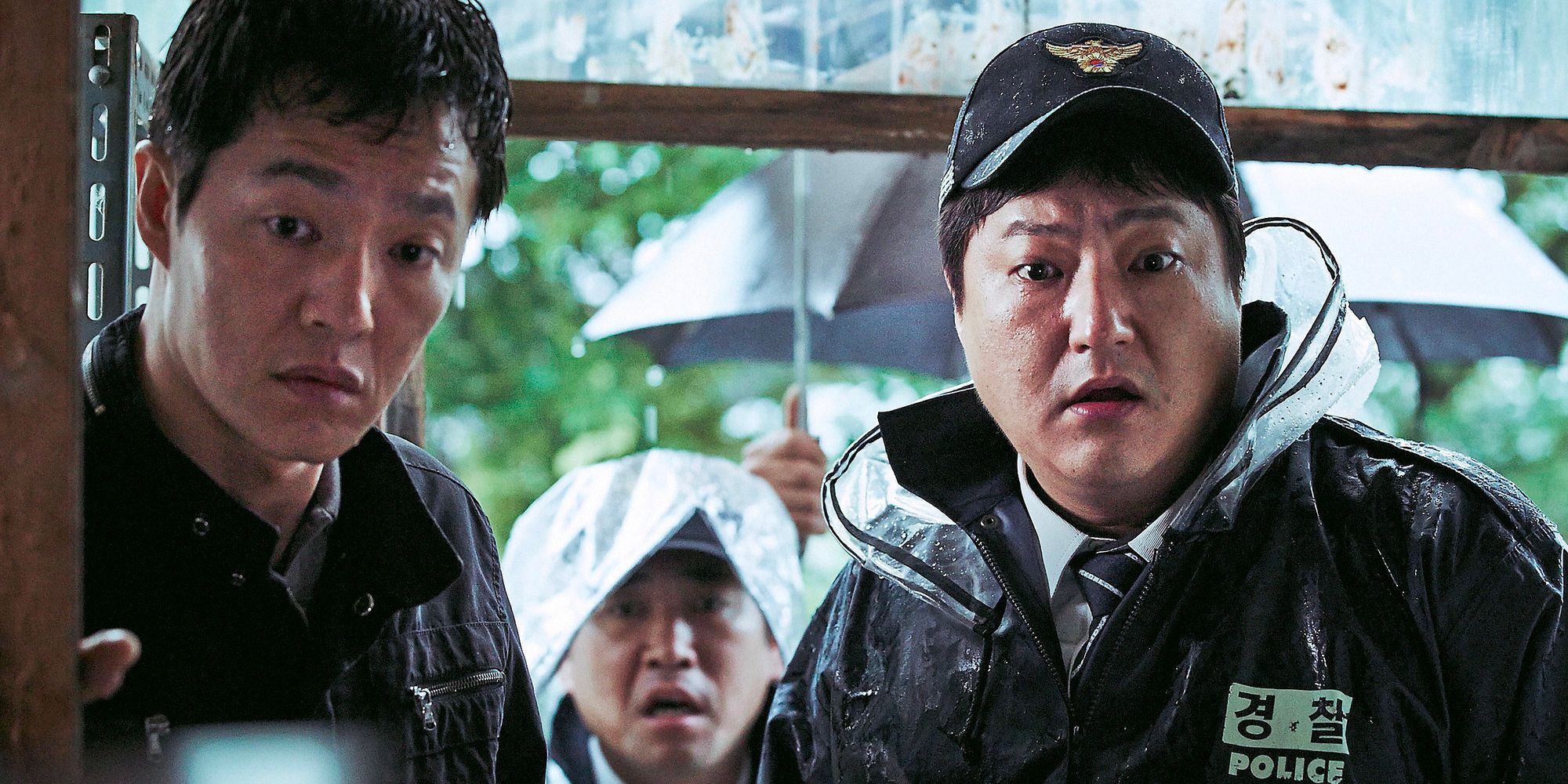 Kwak Do-won and Jo Han-chul standing with shocked looks on their faces in The Wailing.